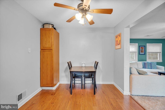 dining area featuring a ceiling fan, light wood-type flooring, visible vents, and baseboards