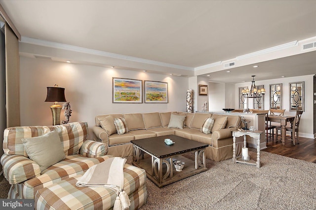 living area featuring visible vents, dark wood-type flooring, an inviting chandelier, and ornamental molding