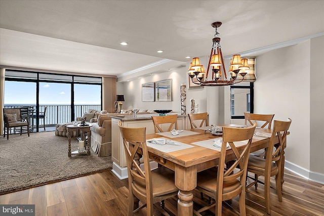 dining space featuring baseboards, ornamental molding, recessed lighting, an inviting chandelier, and dark wood-style floors