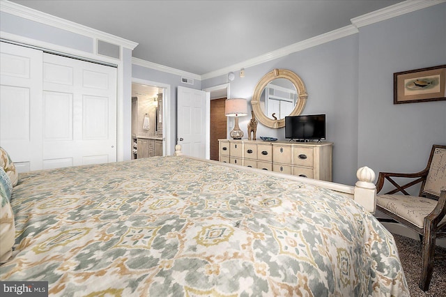 bedroom with a closet, visible vents, ensuite bath, and ornamental molding