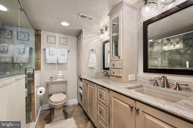 bathroom with toilet, visible vents, a stall shower, and a sink