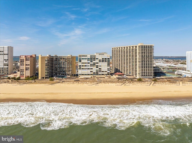 drone / aerial view featuring a view of city, a beach view, and a water view