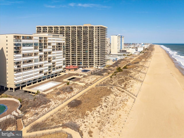 view of building exterior featuring a beach view and a water view