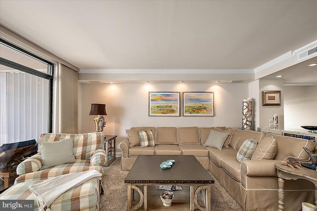 living room with visible vents, carpet floors, and crown molding