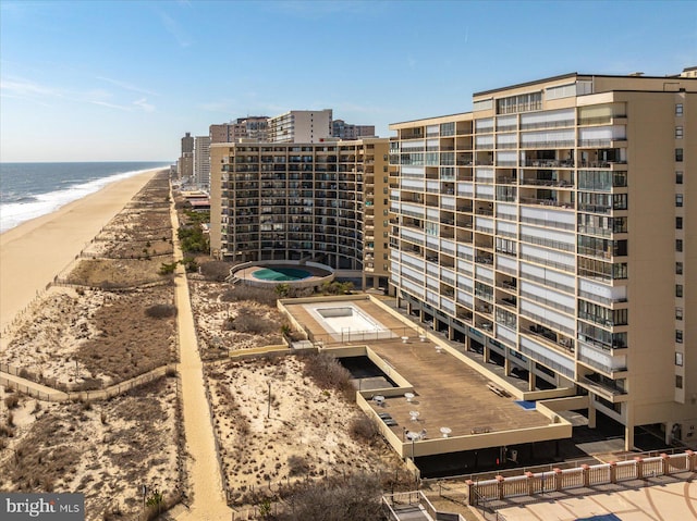 view of property with a water view and a beach view