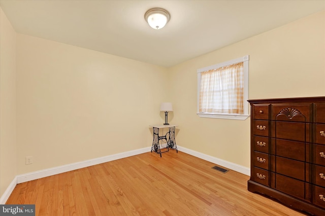 interior space with visible vents, baseboards, and wood finished floors