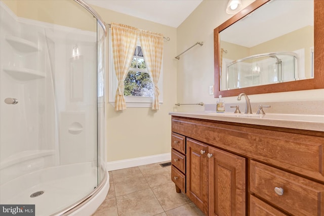 bathroom featuring visible vents, a shower stall, baseboards, tile patterned floors, and vanity