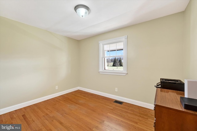 unfurnished office with light wood-style floors, visible vents, and baseboards