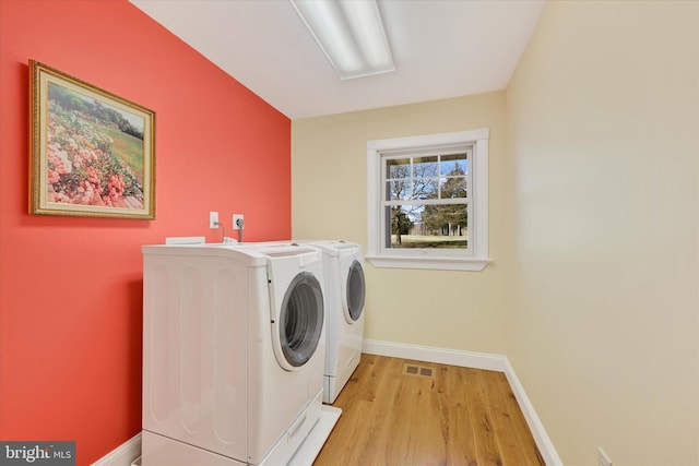 laundry area with visible vents, light wood-style floors, baseboards, laundry area, and washing machine and clothes dryer