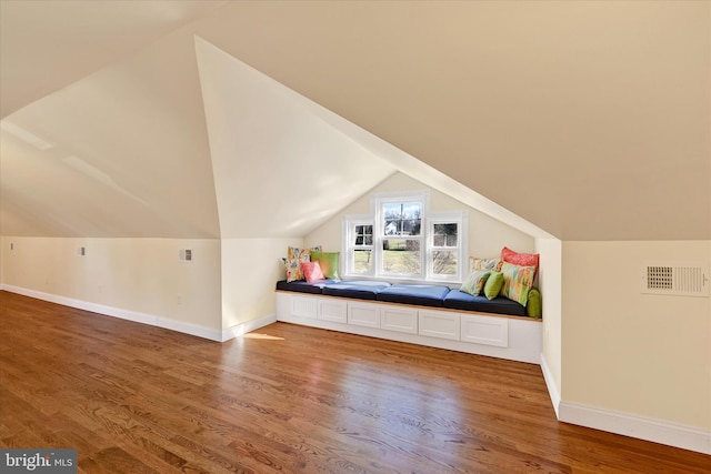 bonus room with vaulted ceiling, wood finished floors, visible vents, and baseboards