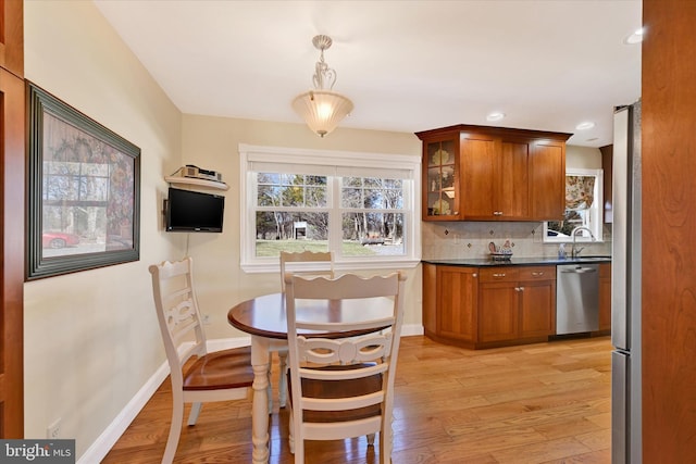 dining room with light wood finished floors, recessed lighting, and baseboards