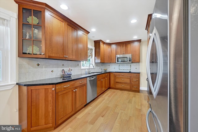 kitchen featuring brown cabinetry, light wood finished floors, and appliances with stainless steel finishes