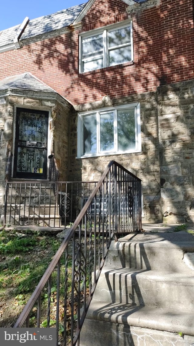 view of exterior entry with stone siding and brick siding