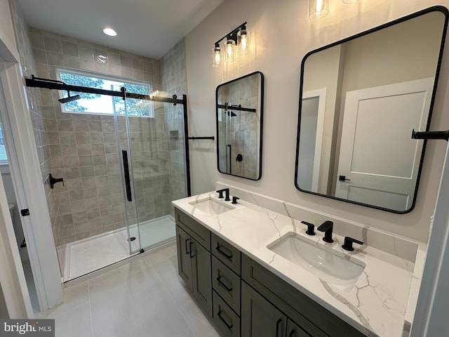 bathroom with double vanity, tile patterned flooring, a sink, and a shower stall