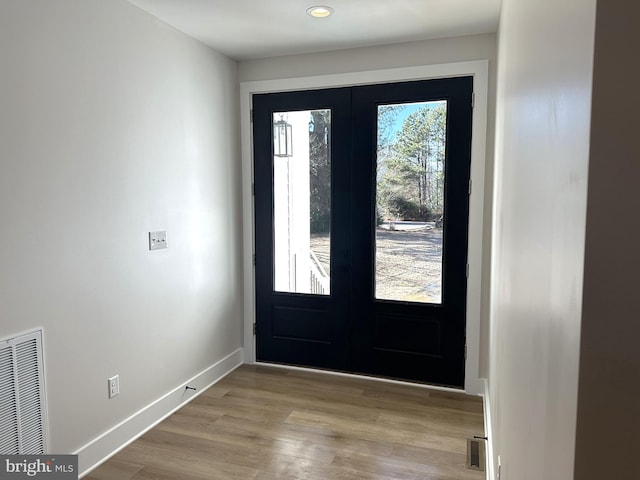 doorway to outside featuring french doors, visible vents, baseboards, and wood finished floors