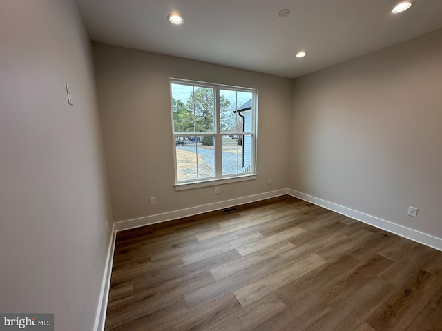 spare room featuring dark wood-style floors, recessed lighting, and baseboards