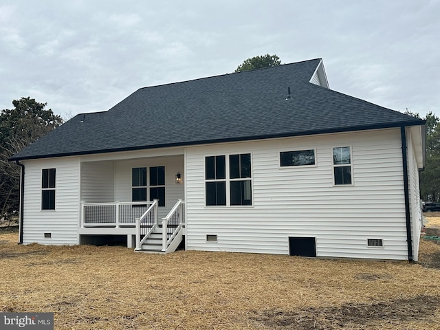 rear view of property featuring crawl space, roof with shingles, and covered porch