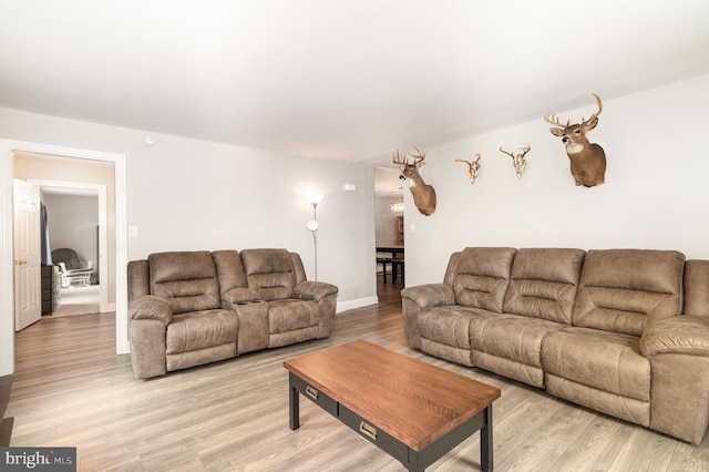 living area with light wood-style flooring and baseboards