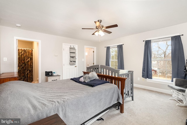 bedroom featuring light carpet, ceiling fan, and baseboards