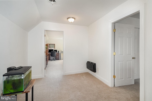 hallway with carpet floors, heating unit, and baseboards