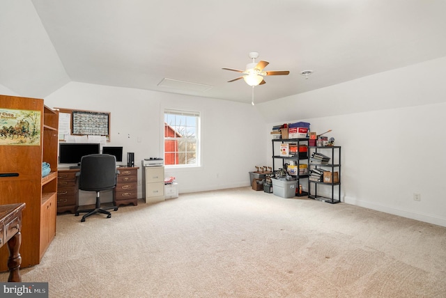 carpeted office space featuring attic access, lofted ceiling, baseboards, and a ceiling fan