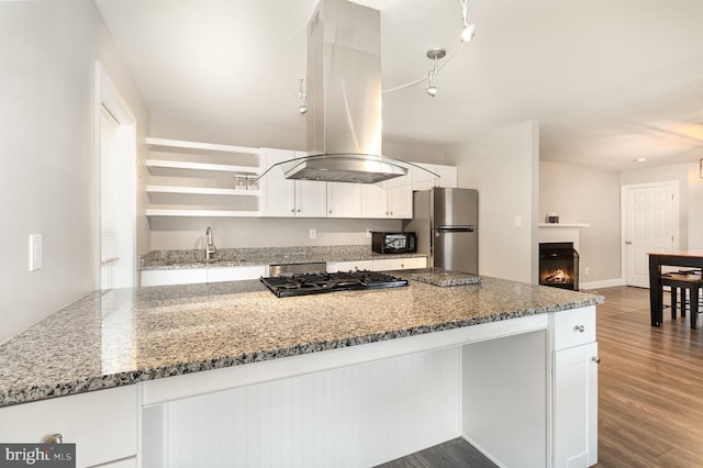 kitchen featuring freestanding refrigerator, dark wood-style flooring, white cabinets, and island range hood