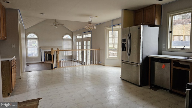 kitchen featuring vaulted ceiling, light floors, appliances with stainless steel finishes, and light countertops