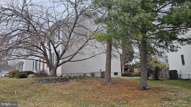 view of side of property with a lawn and central AC unit