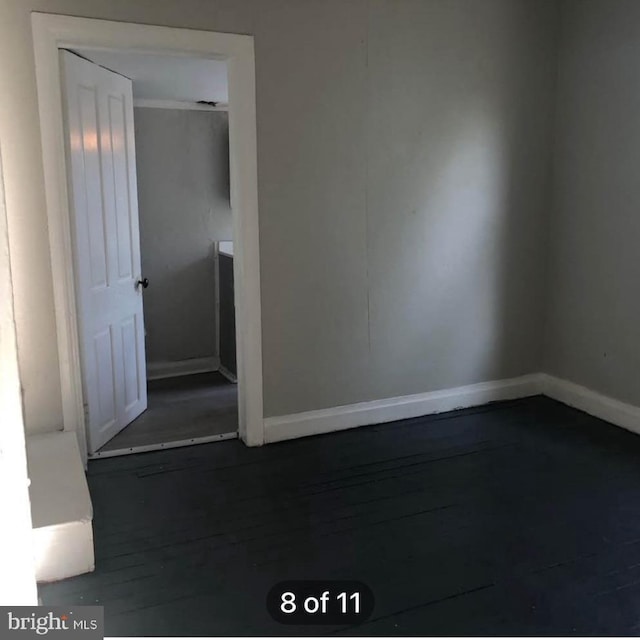 empty room featuring wood finished floors and baseboards