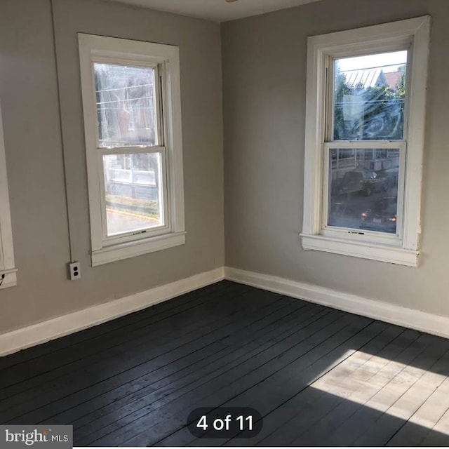 unfurnished room with dark wood-style floors and baseboards