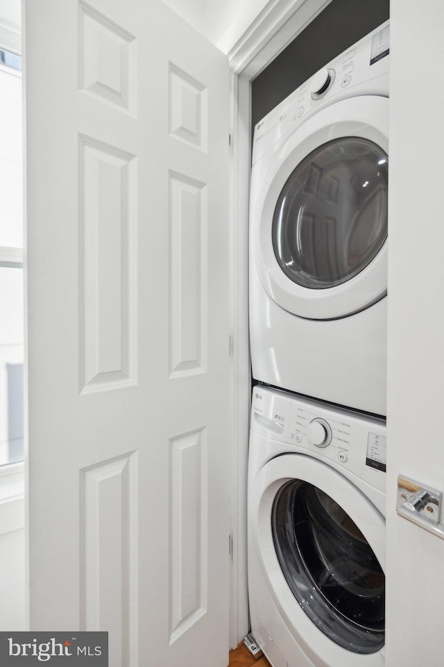 clothes washing area featuring laundry area and stacked washer / dryer