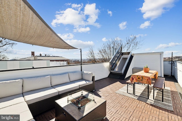 view of patio / terrace with a balcony and an outdoor living space with a fire pit