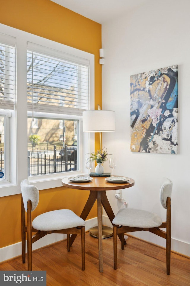 dining room with breakfast area, baseboards, and wood finished floors