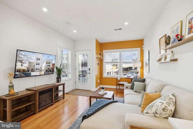 living area with recessed lighting, visible vents, a healthy amount of sunlight, and light wood finished floors