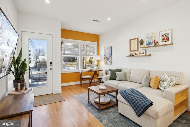 living room featuring recessed lighting, wood finished floors, visible vents, and baseboards