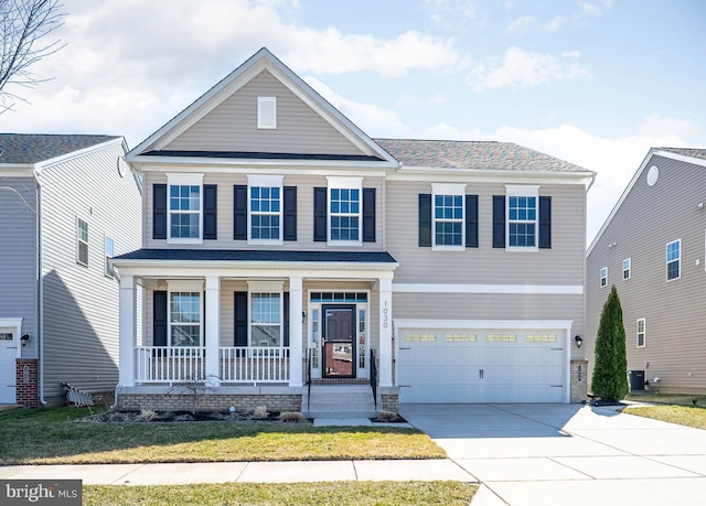 traditional-style home featuring a porch, concrete driveway, a front yard, cooling unit, and an attached garage