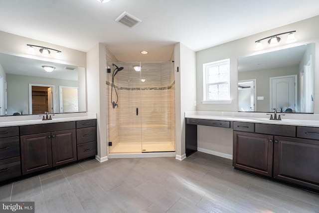 bathroom featuring a stall shower, two vanities, visible vents, and a sink