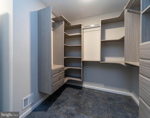 spacious closet featuring stone finish floor and visible vents