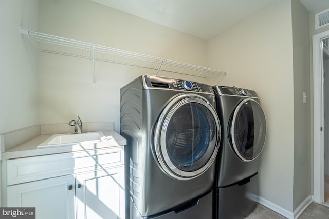 washroom featuring a sink, baseboards, laundry area, and washing machine and clothes dryer