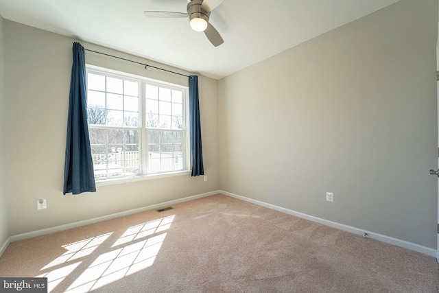 spare room with visible vents, ceiling fan, baseboards, and carpet