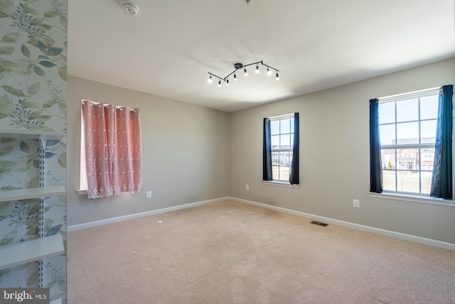 spare room featuring visible vents, baseboards, and carpet flooring