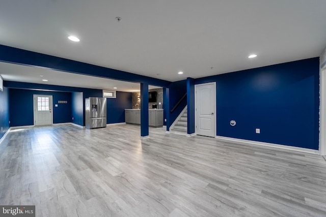 basement with stairway, baseboards, light wood-style flooring, recessed lighting, and stainless steel fridge with ice dispenser