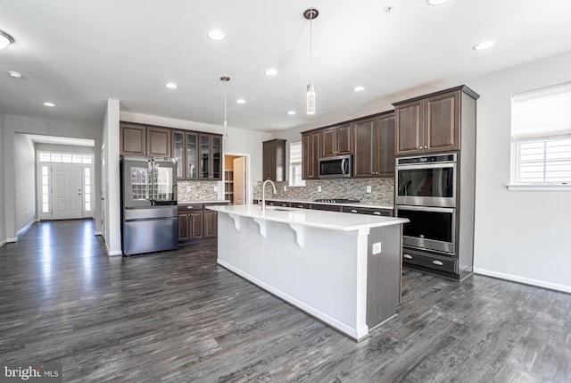 kitchen featuring a sink, appliances with stainless steel finishes, light countertops, and dark brown cabinets