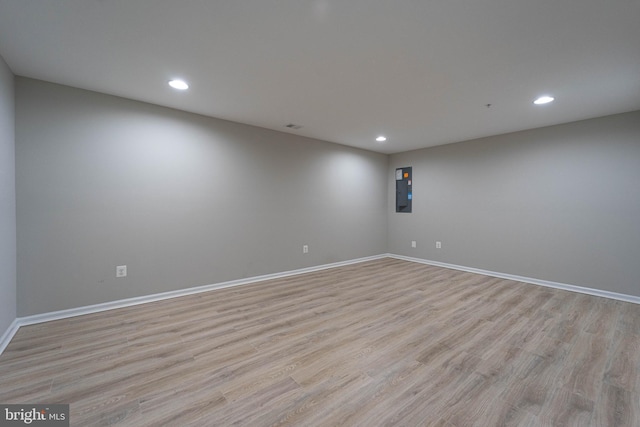 spare room featuring recessed lighting, light wood-style flooring, and baseboards