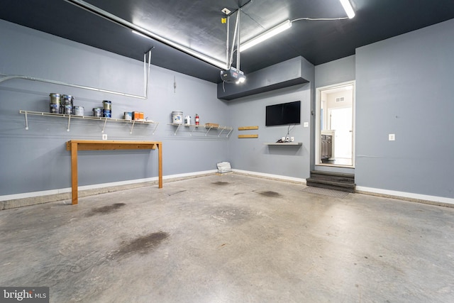 garage featuring a garage door opener and baseboards