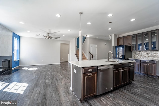 kitchen featuring stainless steel dishwasher, dark wood-style floors, refrigerator with glass door, and a sink