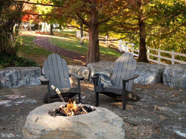 view of patio featuring fence and a fire pit