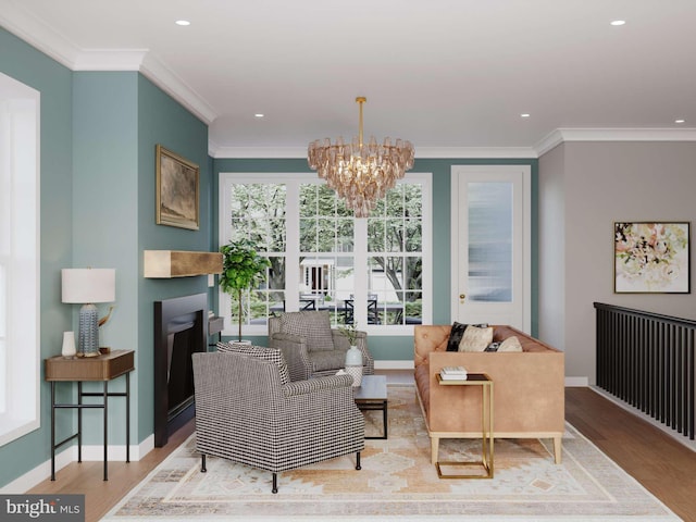 sitting room featuring an inviting chandelier, baseboards, ornamental molding, and wood finished floors