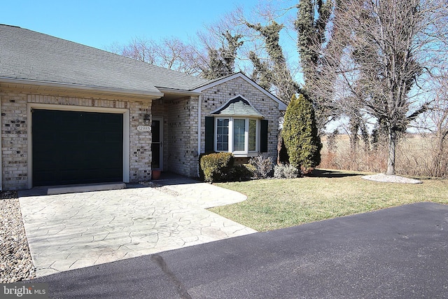 view of front of house with driveway, a front lawn, an attached garage, and a shingled roof