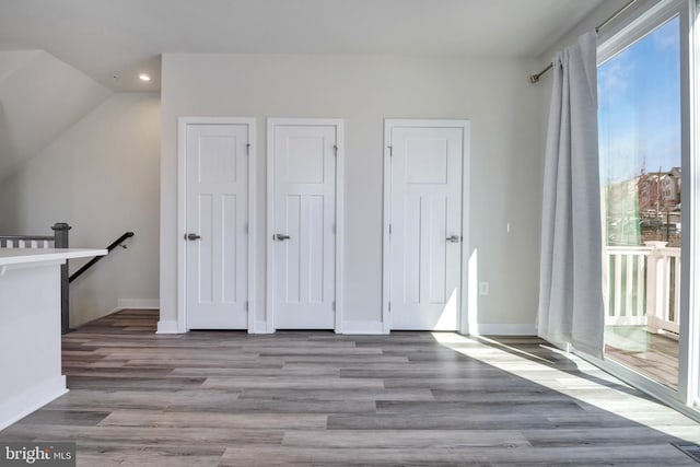 unfurnished bedroom featuring access to outside, recessed lighting, baseboards, and wood finished floors